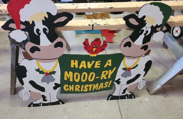 Christmas cows with a holiday sign